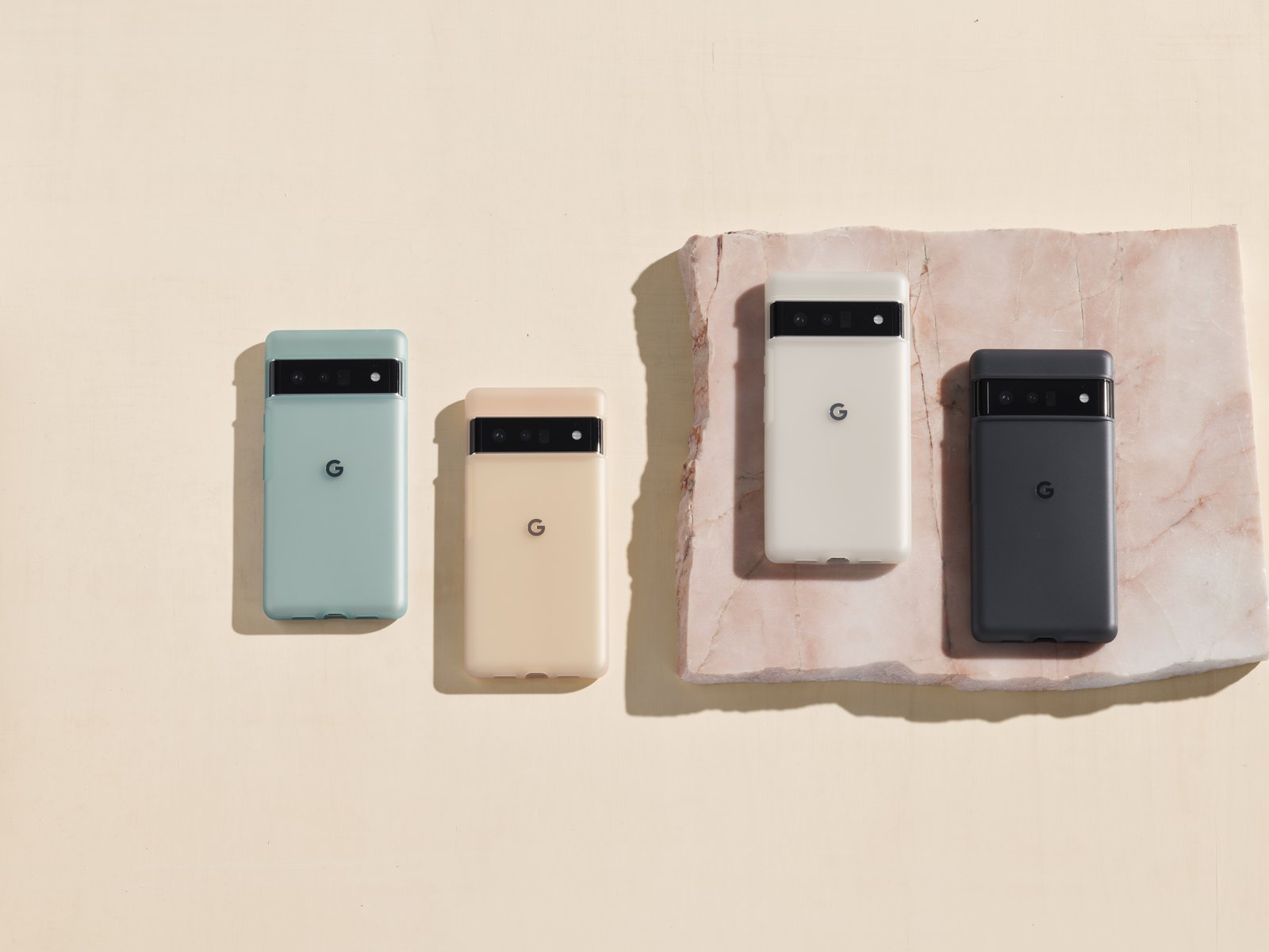 Pixel 6 and Pixel 6 Pro in Google's official cases arranged on a stone slab