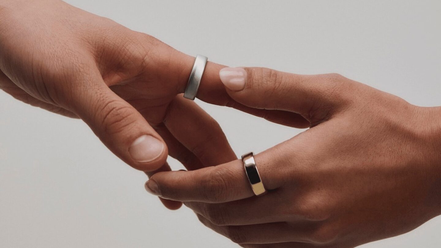 Two hands wearing Oura Ring 5 smart rings in Silver and Gold